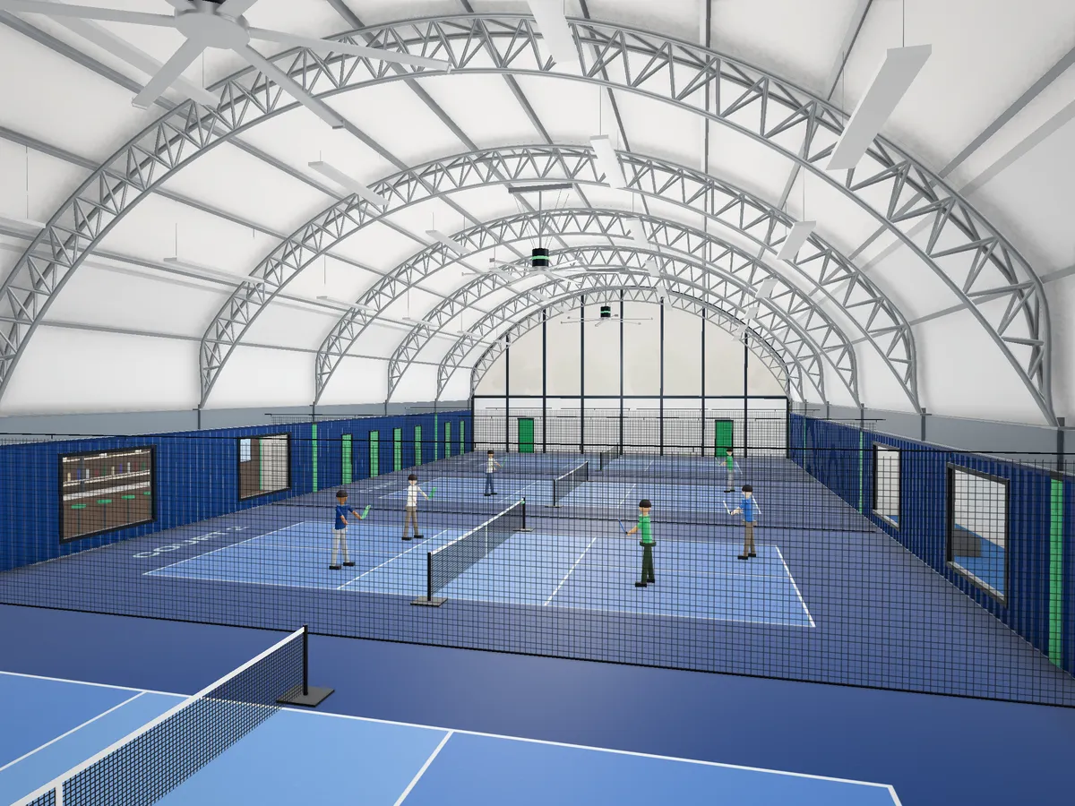 Interior of a Cube Court hall with pickleball courts under the steel arch